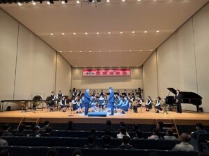 第2校歌の合奏用の楽譜を校長に贈呈する塩崎同窓会長